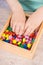 Preschooler playing thread and colorful beads used to making bracelets. Development of kids motor skills, creativity and logical