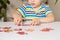 A preschooler plays puzzles, puts together a picture, close-up of his hands.