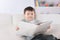 Preschooler reading a book on the couch in the nursery