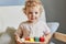 Preschooler\\\'s logical skills. Creative imagination play. Wavy haired little blonde baby girl palying with wooden sorter