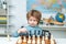 Preschooler or schoolboy, Thinking child. Chess strategy. Kid playing chess.