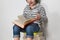 Preschooler sitting on a pile of books