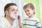 Preschooler watching shaving of his dad