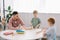 preschoolers playing wit h wooden block with teacher near by