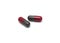 Prescription drugs, capsules of red and dark gray colors all mixed in.