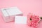Present box and pink carnations with a blank card