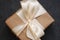 Present Brown Craft Gift. Close up of Ribbon Bow on Darck Background. Cristmas or Winter Concept.