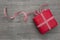 Present wrapped in red paper on a wooden background, checkered ribbon