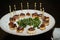 Presentation of small slices of bread with a mackerel skewer with caviar during a catering event. Food concept, menu, catering