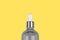 Presentation of trendy colors 2021 - gray and yellow. Close-up of glass dropper bottle on yellow background