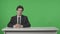 Presenter Reporting. Anchorman Talks, Listens, Nods against the background of a green screen. Newsroom Studio Concept