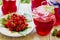 Preserved homemade red currant jam in glass jars on white wooden table. Fresh berries and green leaves, vintage plate