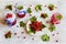 Preserved homemade red currant jam in glass jars on white wooden table. Fresh berries and green leaves, vintage plate, top view