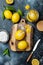 Preserved, salted canned lemons on a wooden board over black stone background. Moroccan cuisine.