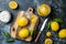 Preserved, salted canned lemons on a wooden board over black stone background. Moroccan cuisine.