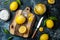 Preserved, salted canned lemons on a wooden board over black stone background. Moroccan cuisine.