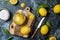 Preserved, salted canned lemons on a wooden board over black stone background. Moroccan cuisine.