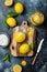 Preserved, salted canned lemons on a wooden board over black stone background. Moroccan cuisine.