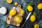 Preserved, salted canned lemons on a wooden board over black stone background. Moroccan cuisine.