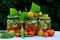 Preserves vegetables in glass jars on the table in summer garden. glass jars with various vegetables