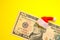 President Hamilton in a red Santa Claus hat on a ten US dollar bill against a bright yellow background. The concept of the cost of