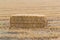 Pressed hay straw briquette left of harvest lying on a field