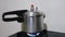 Pressure cooker on fire stove, cooking process in household or commercial kitchen