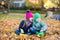 Preteen boy and girl play with yellow foliage