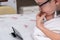 A preteen boy in glasses lying on a bed and watching video on smartphone