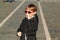 Preteen boy having fun outdoors. Boy wearing trendy sunglasses. Urban street style. Boy enjoying with scooter on a walk at sunny