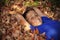 Preteen boy laying in autumn leaves