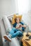 Preteen boy lying with guitar on cozy sofa dressed casual jeans and new sneakers listening to music and chatting using wireless