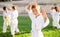 Preteen boy practicing karate during group class on green lawn