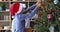 Preteen boy single dad hang Christmas ornaments on fir tree