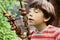 Preteen boy smell shashlik meat on summer picnic