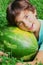 Preteen boy smiling hug whole water melon