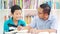 Preteen boy studying with his father in library