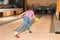 Preteen boy throwing ball at bowling