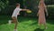Preteen boy throwing flying disk to sister in park. Cute girl catching disk