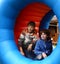 Preteen boys in amusement park in rolling rubber barrel