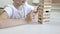 A preteen caucasian boy playing wooden block tower board game with his mom for practicing physical and mental skill and