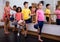Preteen children practicing dance moves near ballet barre
