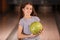 Preteen girl with ball in bowling