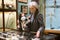 Preteen girl and elderly woman in protective masks viewing antique handguns in museum