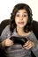 Preteen girl with eyes wide open playing video game excited