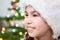 Preteen girl facial portrait on Christmas tree light background, copyspace