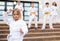 Preteen girl mastering karate moves during group class outdoors