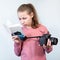 Preteen girl reading service manual book for her dlsr camera, beginner is learning photography, grey background