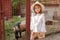 Preteen girl standing near stall with goat in country estate in summer