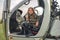 Preteen girl wearing camo style dress sitting in open helicopter